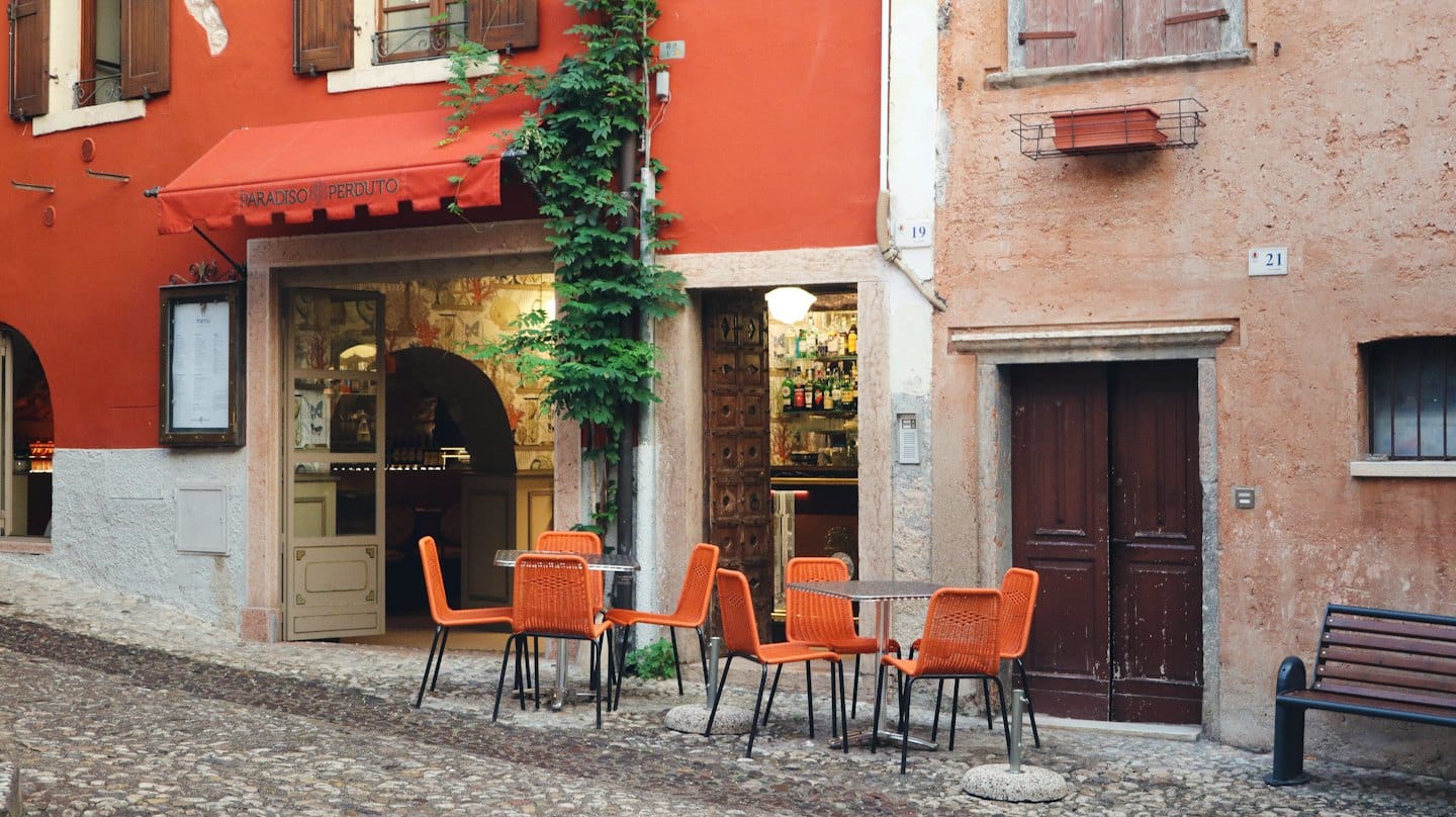 European cafe with outdoor seating on a cobblestone street.